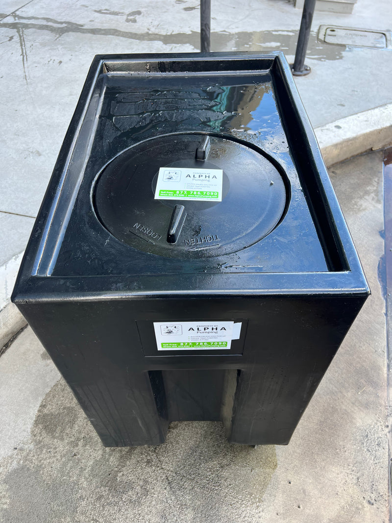 A Black Grease Collection Bin on a Concrete Sidewalk